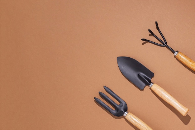 Gardening tools on a brown background. Top view, flat lay.