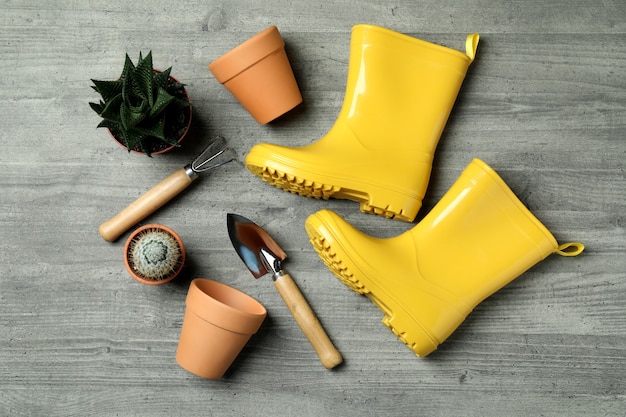 Gardening tools on gray textured, top view