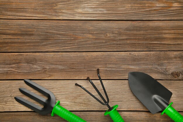 Gardening tools on grey wooden background, top view