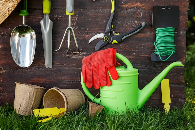 Gardening tools and a straw hat on the grass in the garden.