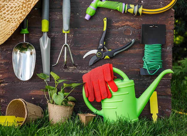 Gardening tools and a straw hat on the grass in the garden.