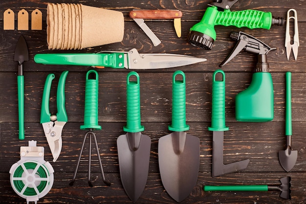 Photo gardening tools on wooden background flat lay