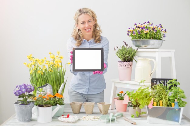 Photo gardening woman holding tablet and smiling