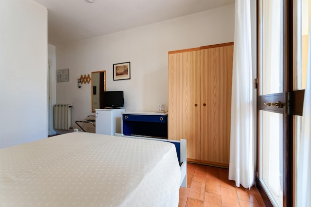 이탈리아 가르냐노 - 2019년 7월 14일: 모던하고 편안한 실내. 호텔이나 집에서 침실의 고급 아파트 인테리어입니다. 아키텍처 개념 및 디자인입니다. 집에서 방에 더블 침대입니다. 혼합 매체.
