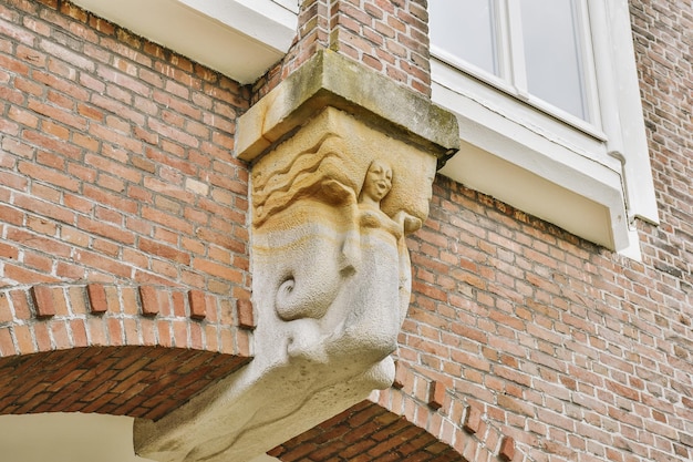 Photo a gargoyle on the side of a brick building