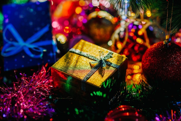 A garland on a Christmas tree shines beautifully in different colors