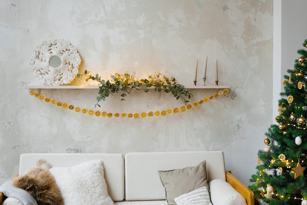 Garland of dried oranges or lemons on the shelf above the sofa and Christmas tree