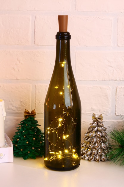 Garland in de fles. Lege champagnefles met slinger binnen op witte lijst.