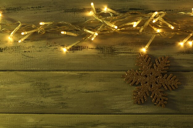 Garland and snowflake on wooden background