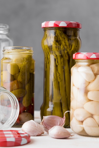 Garlic, asparagus and olives preserved in glass jars