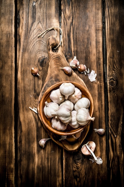 Garlic background . Fresh garlic on old wooden Board.