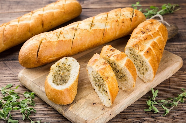 Foto rotolo di baguette all'aglio su un tagliere di legno