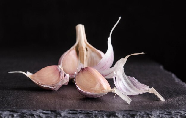 Garlic on black stone table on black background