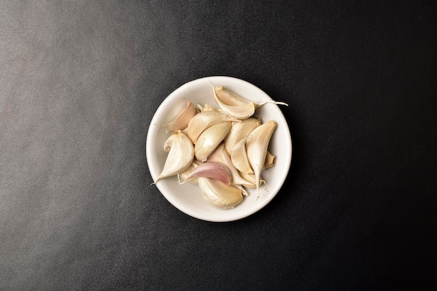 Garlic in bowl on dark background