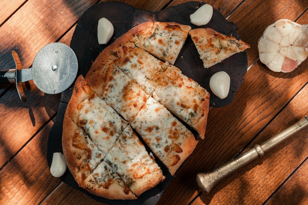 Garlic bread. Fresh garlic bread with garlic and herbs on wooden table, flat lay.