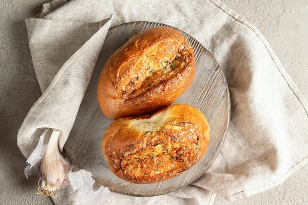 Garlic bread on a round wooden board cotton napkin on the table