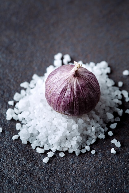 Garlic bulb on salt heap close-up