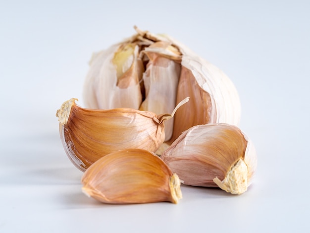 Garlic bulbs and cloves isolated on white surface