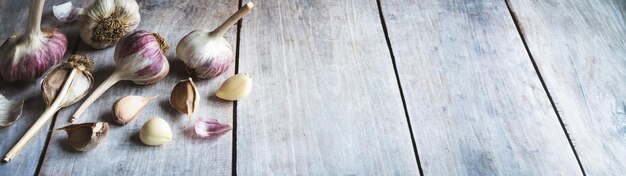 Garlic bulbs and cloves on wooden table food background copy space