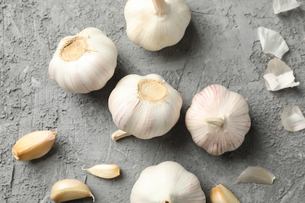 Garlic bulbs, slices on grey background, closeup. Top view