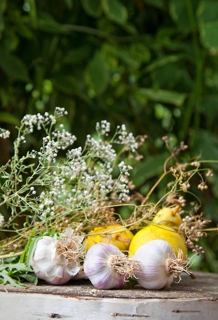 Bulbi d'aglio ed erbe aromatiche su fondo di legno naturale