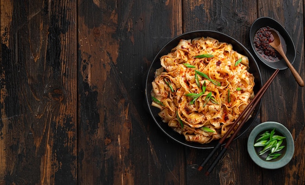 Garlic chili oil noodles on a dark rustic background chinese cuisine top view copy space