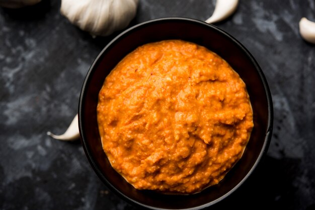 Garlic chutney, made using lahsun or lehsun originating from the India, served in a bowl over moody background. selective focus