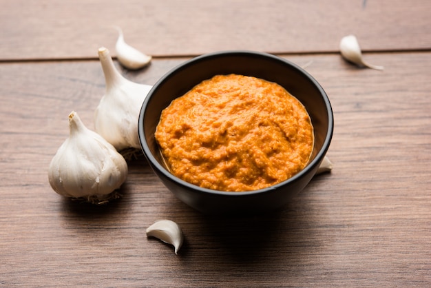 Garlic chutney, made using lahsun or lehsun originating from the India, served in a bowl over moody background. selective focus