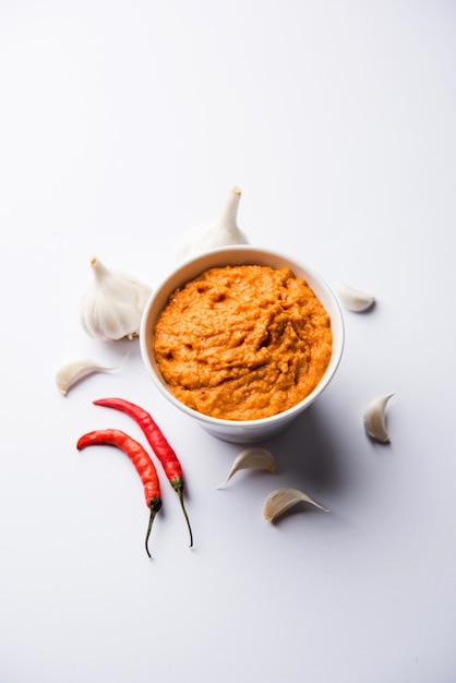 Garlic chutney, made using lahsun or lehsun originating from the India, served in a bowl over moody background. selective focus