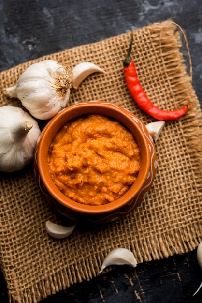 Garlic chutney, made using lahsun or lehsun originating from the India, served in a bowl over moody background. selective focus