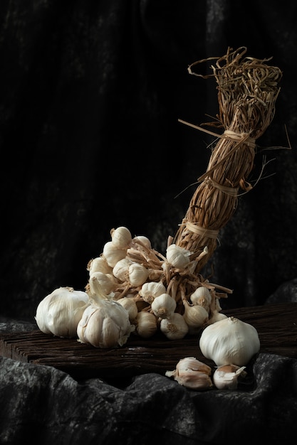 Garlic cloves and bulb on vintage wood black cloth 