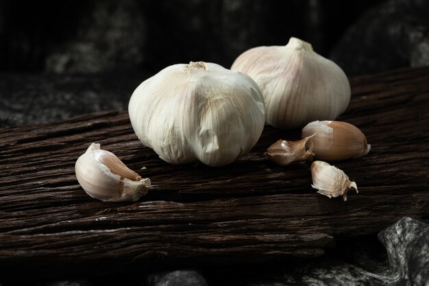 Garlic cloves and bulb on vintage wood black cloth 