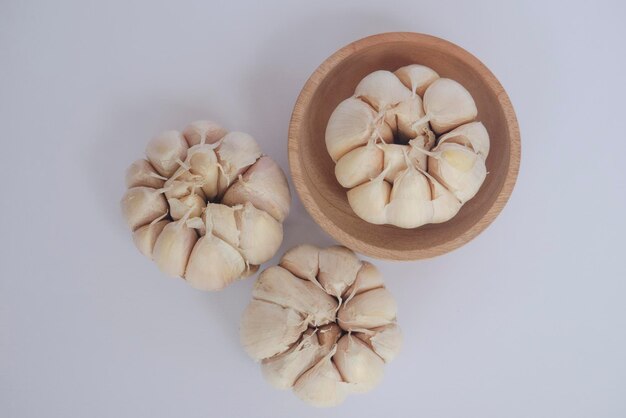 Garlic cloves and bulb in wooden bowl Healthy food Garlic with white isolated object Flat lay