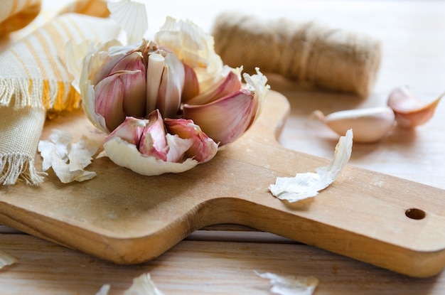 Garlic cloves and garlic bulb on wooden cutting board. Garlic is used as seasoning and as a traditional medicine.