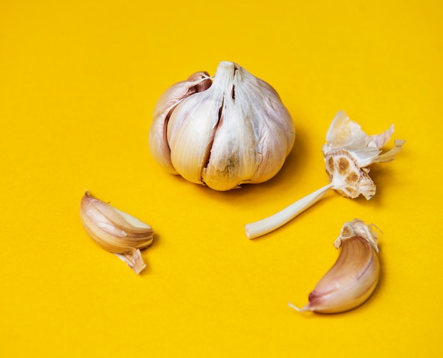 Garlic cloves on yellow background