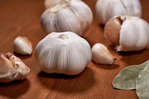 Garlic and garlic cloves on wooden background.