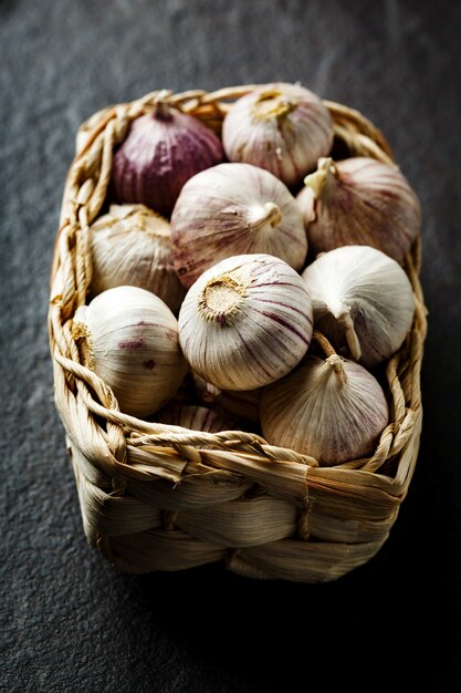 Garlic gloves in a basket on dark grey background