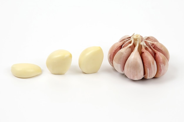 Garlic head and cloves on white background
