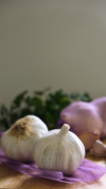 Garlic heads on purple cloth and garlic cloves on a wooden board