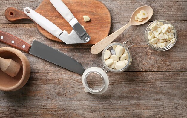 Foto aglio e utensili da cucina su sfondo di legno