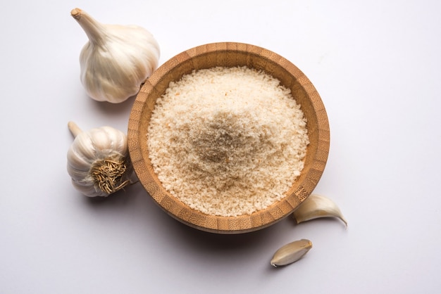 Garlic or Lahsun powder is ground, dehydrated garlic. It's a common seasoning  for pasta, pizza and grilled chicken. Over white background, selective focus