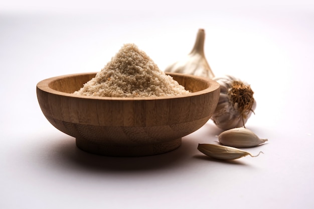 Garlic or Lahsun powder is ground, dehydrated garlic. It's a common seasoning  for pasta, pizza and grilled chicken. Over white background, selective focus