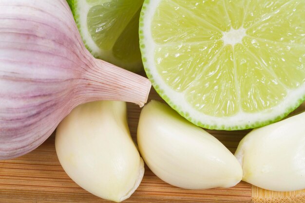 Photo garlic and lemon in bowl on wooden table