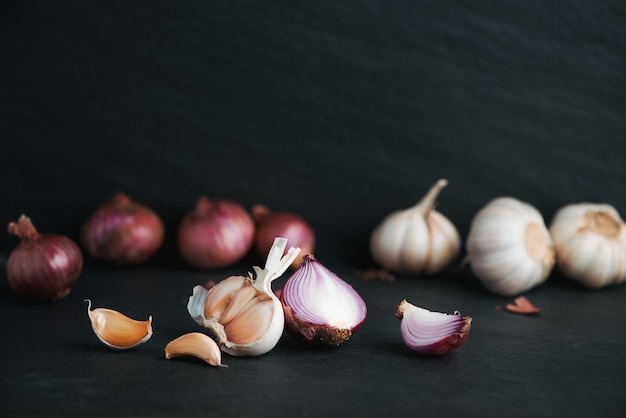 Aglio e cipolla sul tavolo di pietra nera