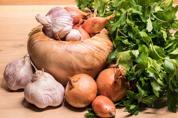 Garlic onion shallot parsley with pestle and olive wood mortar