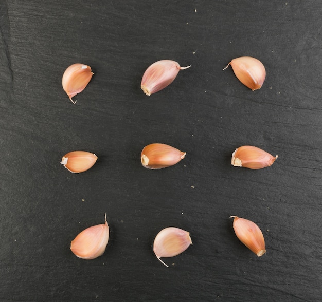 Photo garlic pattern on black stone background