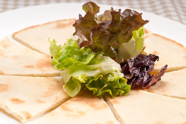 Garlic pita bread pizza with salad on top