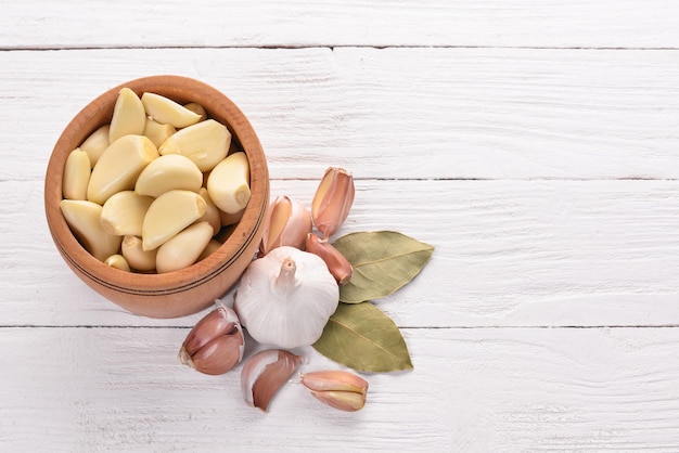 Garlic A set of fresh garlic on a white wooden background Top view Copy space