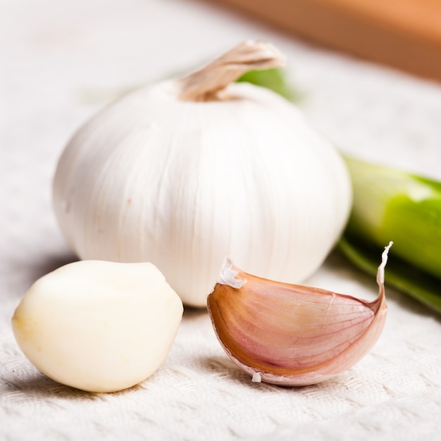 Garlic on tablecloth in the kitchen closeup