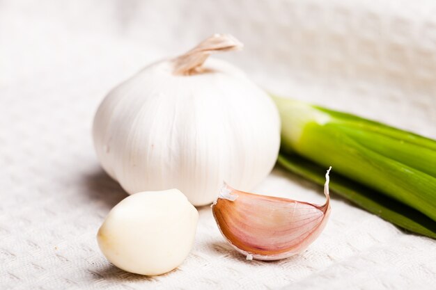 Garlic on tablecloth in the kitchen closeup